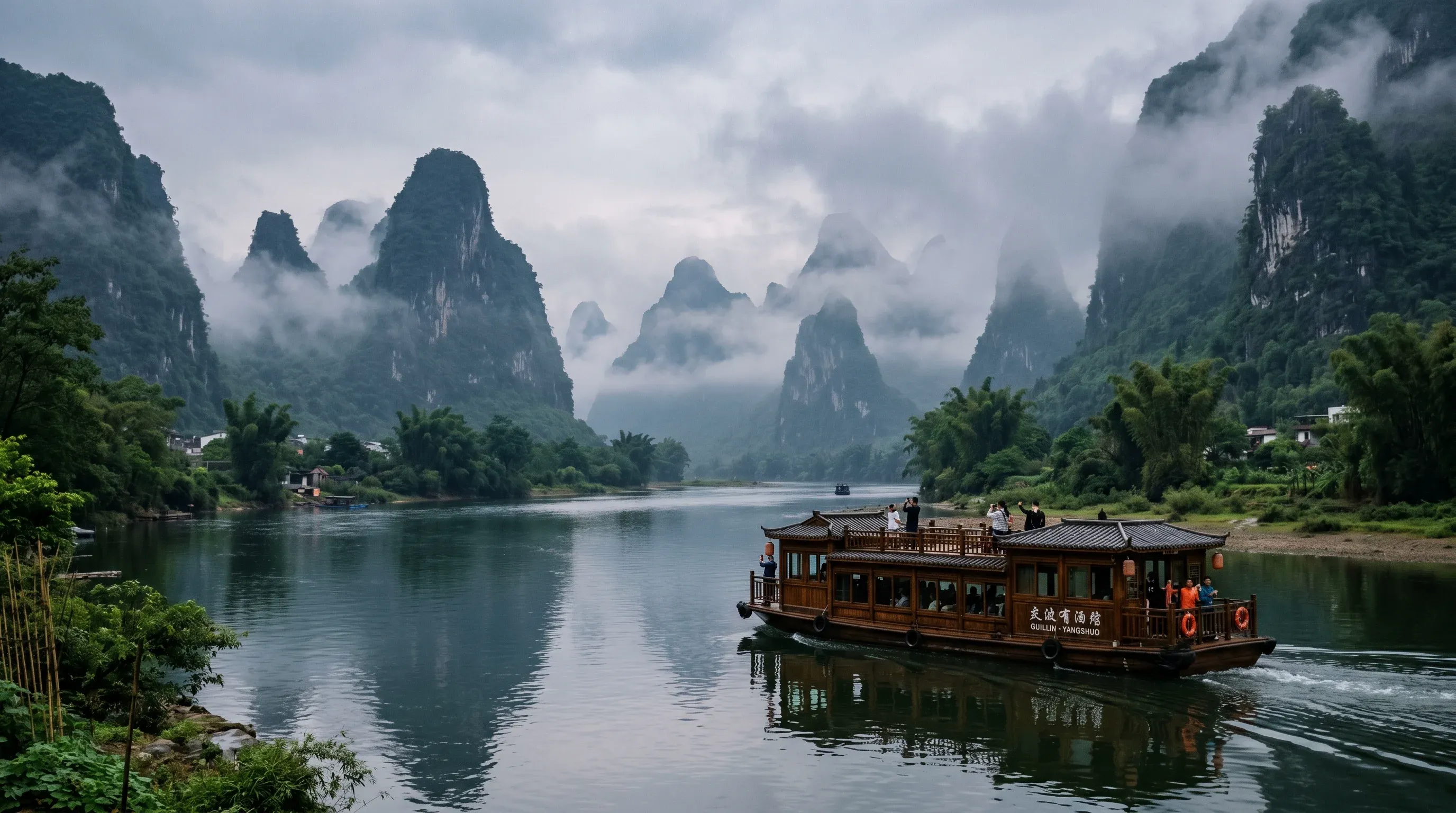Tourist boat cruising the Li River between karst peaks from Guilin to Yangshuo
